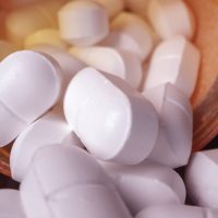 Prescription drugs poured out of bottle viewing them up close.
